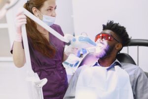 A dentist performing a teeth whitening procedure