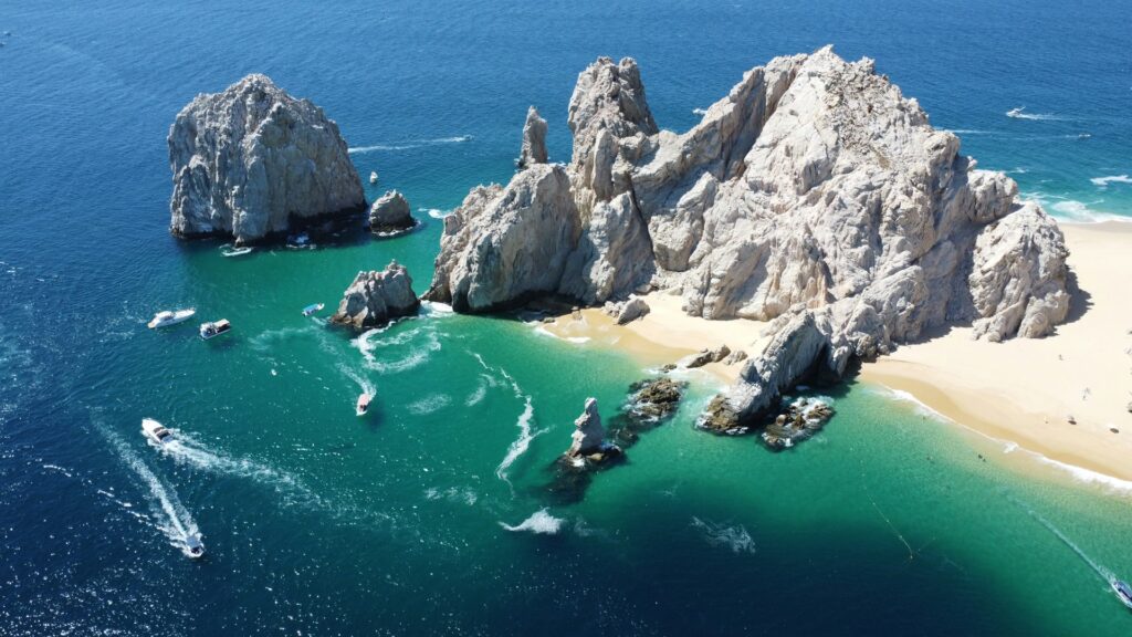 an aerial view of an ocean with rocks near the shore