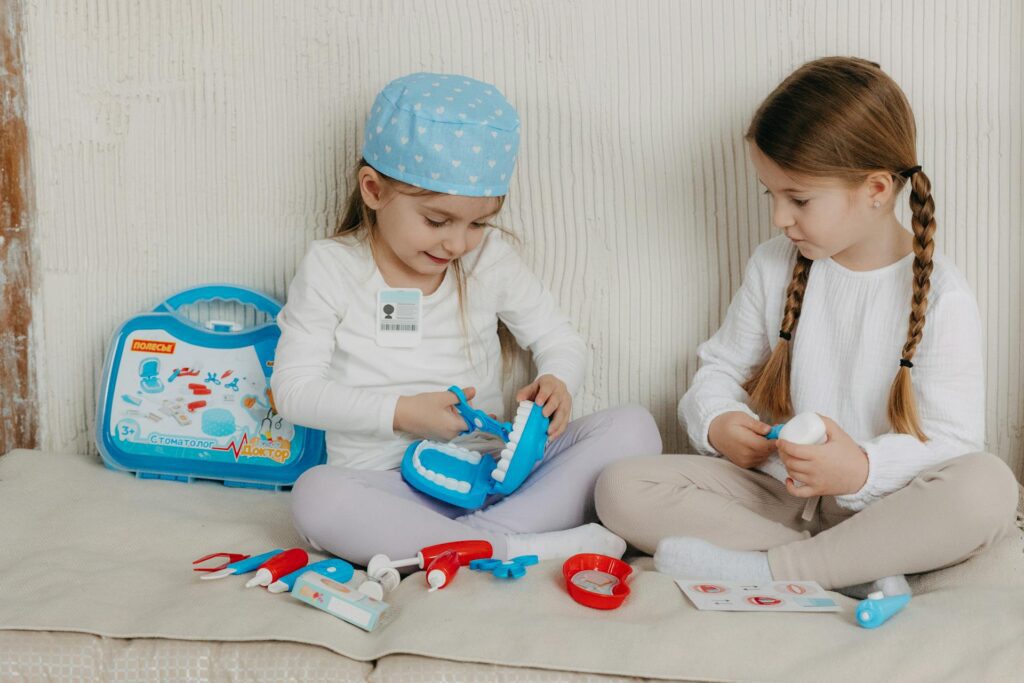 Two little girls playing with a dentist playset after finding a pediatric dentist