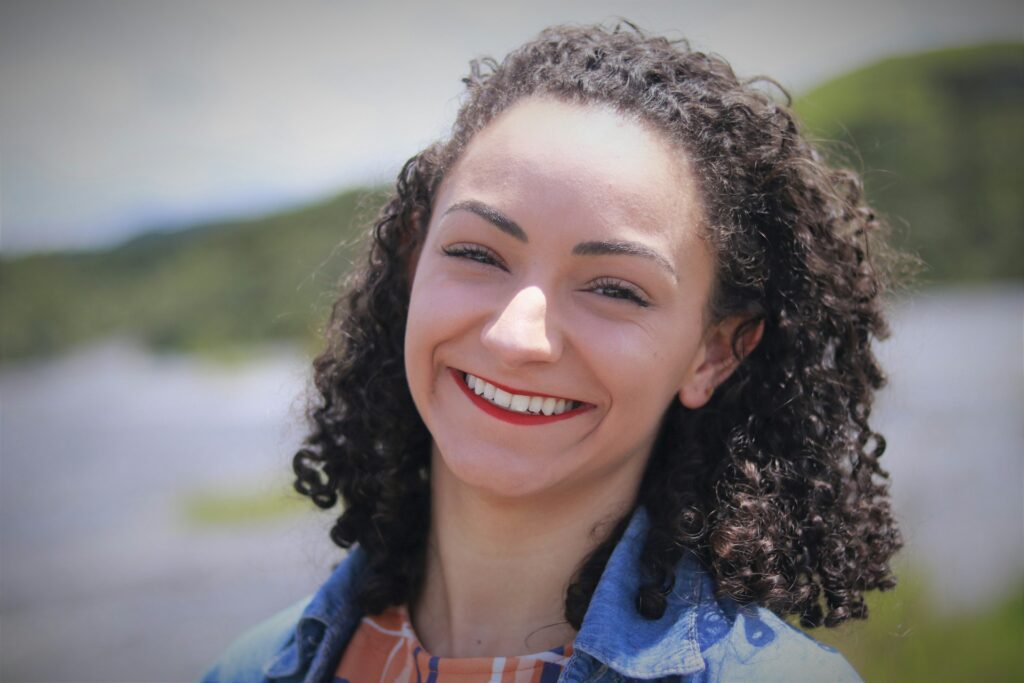 A woman smiling with neat, pearly white teeth after reaping the benefits of cosmetic dentistry